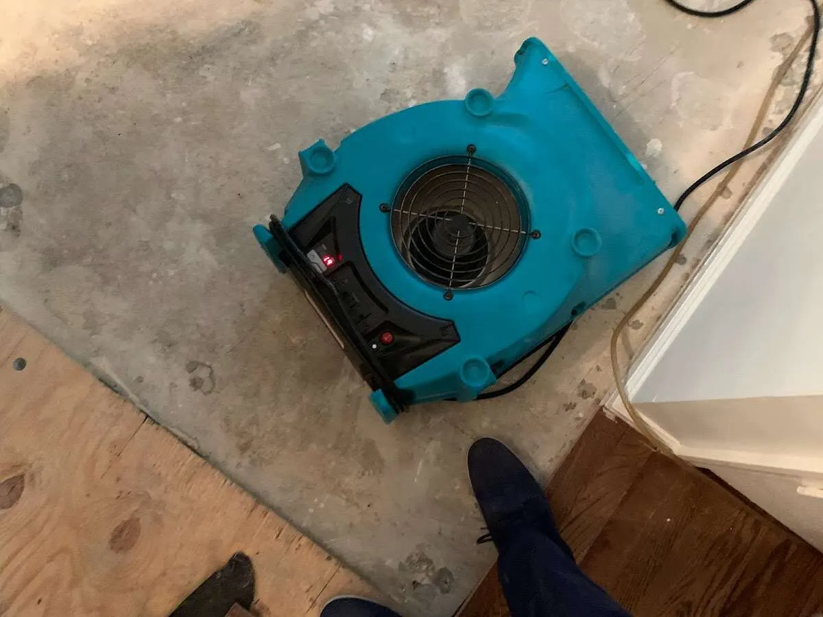 Air mover drying subfloor during Leak Detection & Repair in Atkinson